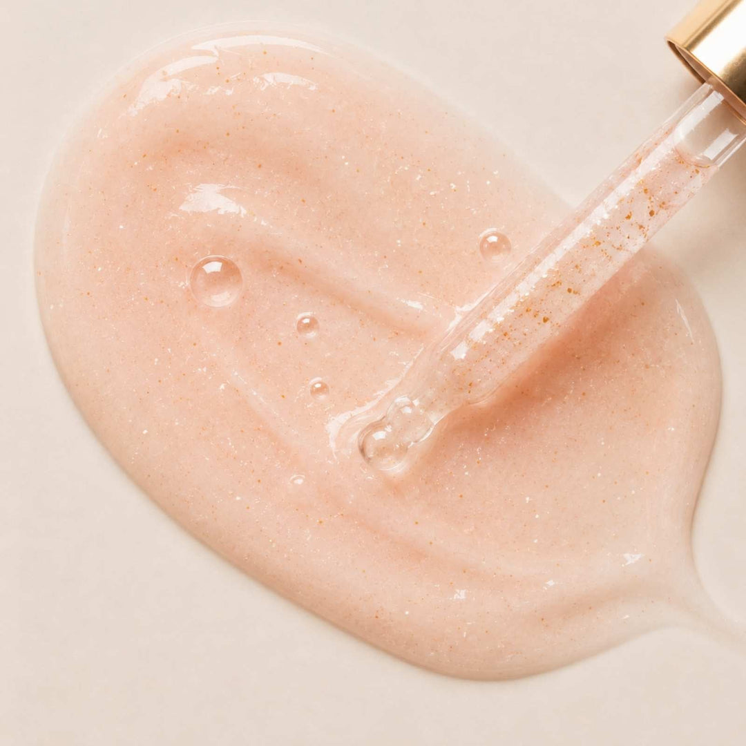 Pipette appliziert ein transparent-rosa, glänzendes Gesichtsserum für intensive Feuchtigkeit.