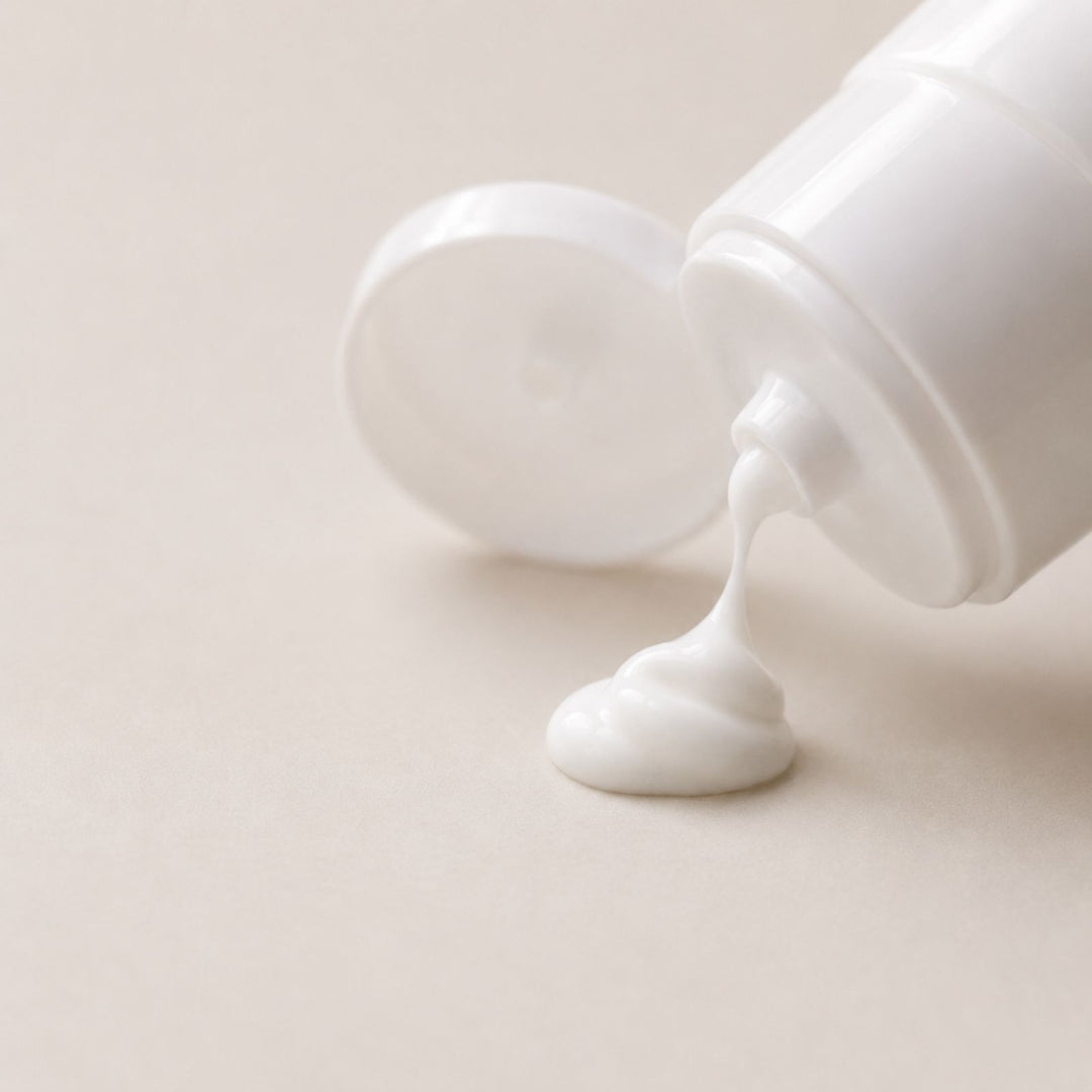 Careskin Handcreme Tube geöffnet mit auslaufender Creme – weiße Handcreme-Textur auf beigem Hintergrund